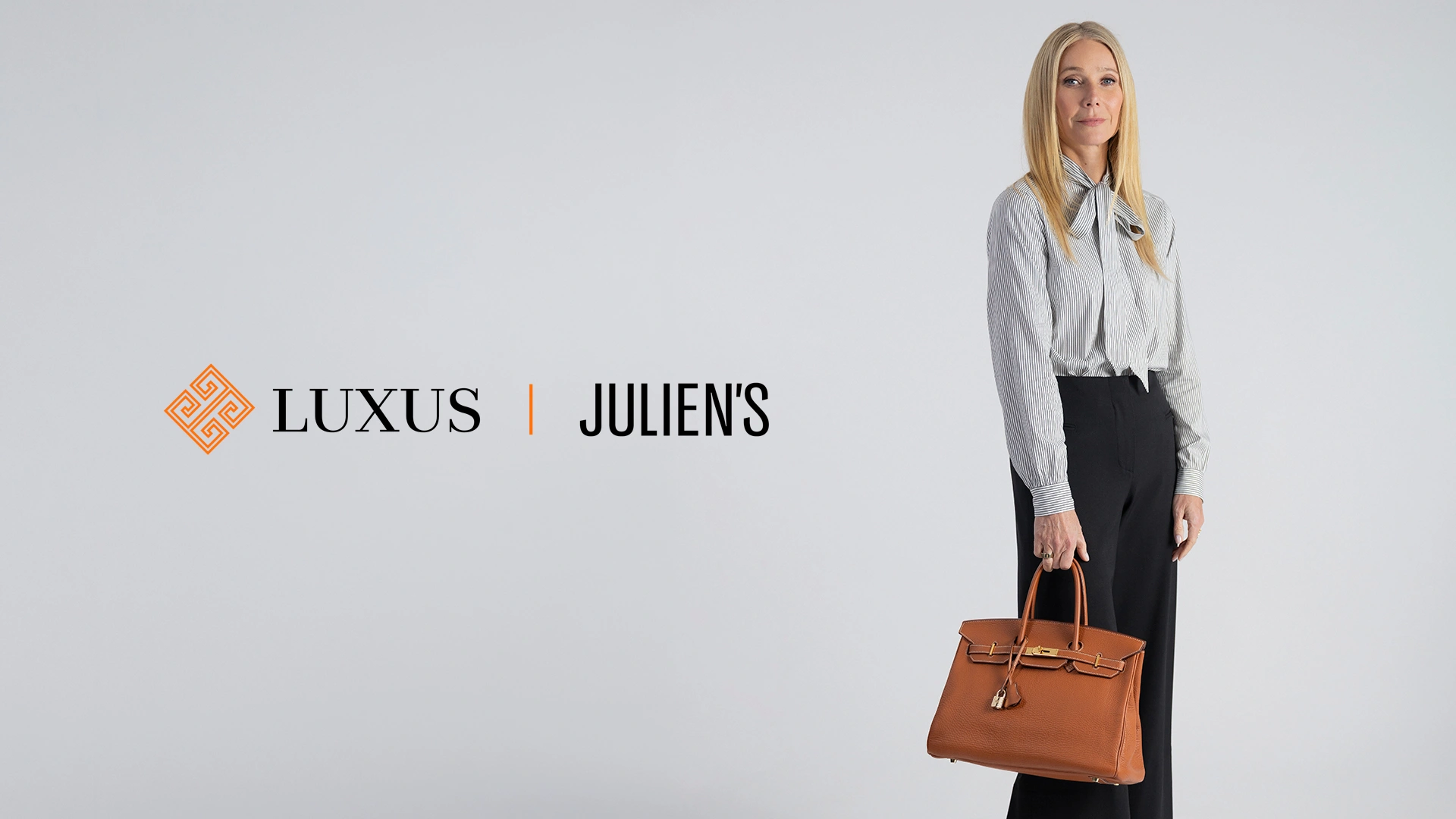 LUXUS x JULIEN'S showcase - woman holding Hermès Birkin